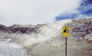 yellow danger sign in the alpine mountains, garmisch, bavaria