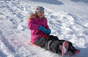 girl rides a pink sled