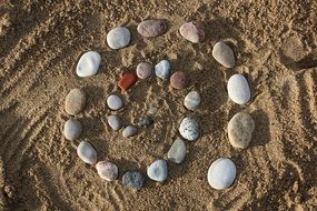 Small beach stones in shape of spiral on a sand