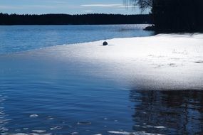 Beautiful white spring ice on Ã¶resjÃ¶ lake near the shore