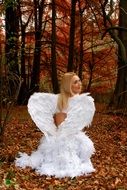 Angel, costumed girl in forest at fall