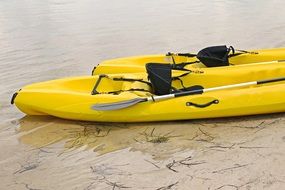 two yellow kayaks on the shore
