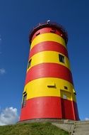 red and yellow Lighthouse at blue Sky