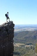 tourist with a backpack on top of a cliff