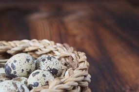 quail eggs in a basket on a wooden table