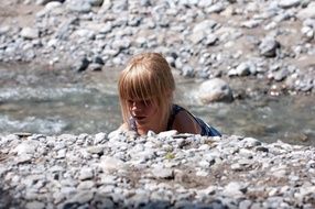 Girl on the rocky creek