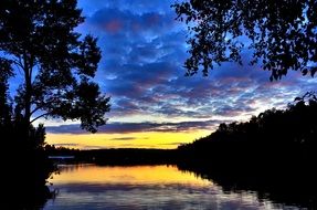 lake with trees on the shore at dusk