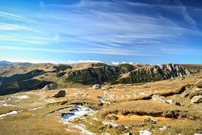 Beautiful rocky mountain under blue sky with white clouds in Romania