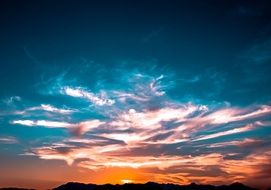 orange sunset on the horizon behind the clouds