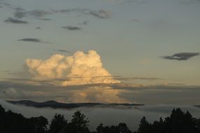 white cumulus clouds over the tops of the mountains