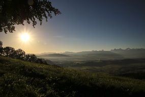 the sun in the sky during sunset over the hill