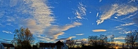 sky with clouds above buildings and trees