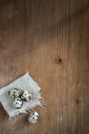 Organic quail eggs on the wooden table in light