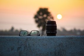 glasses lie next to the camera lens