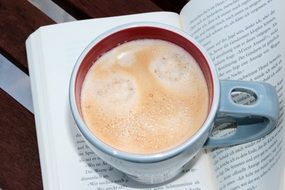 cup of coffee on the open book