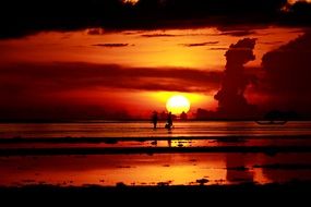 two silhouettes of fishermen at sunset