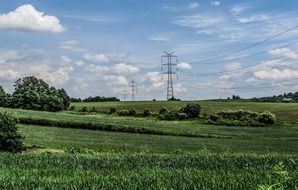 high voltage lines among green meadows