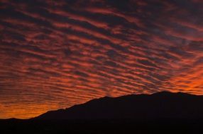 fiery sunset over black hill in Joshua National Park, California