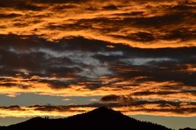 fiery clouds over a dark hill