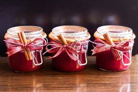 three transparent jars with cranberry jam