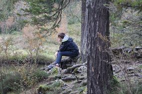 Thinking man near the tree in the forest