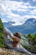 young man resting on top of a mountain