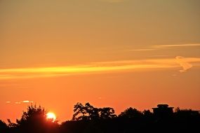 the sun set behind the trees at sunset
