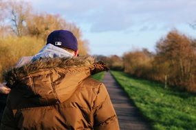 man in a jacket along the trail in the autumn landscape on blurred background