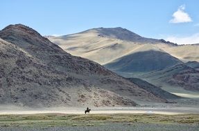 distant view of a rider in the mountains of mongolia