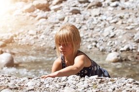 Girl iterates over stones in a mountain stream