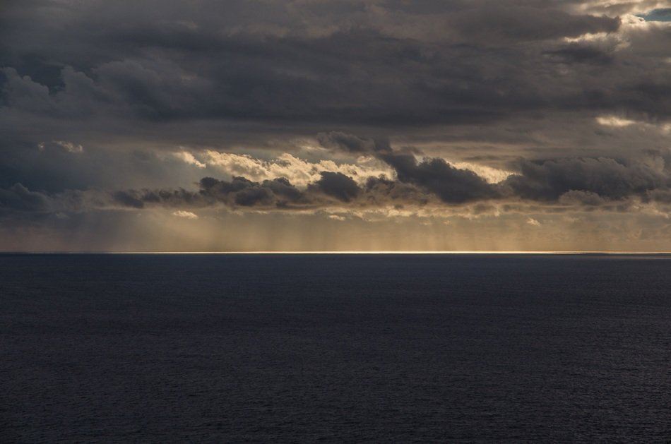 the light of the evening sun behind the clouds