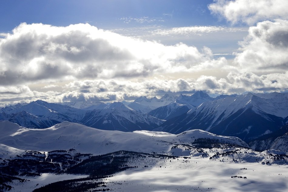 clouds over snowy rocky mountains in alberta