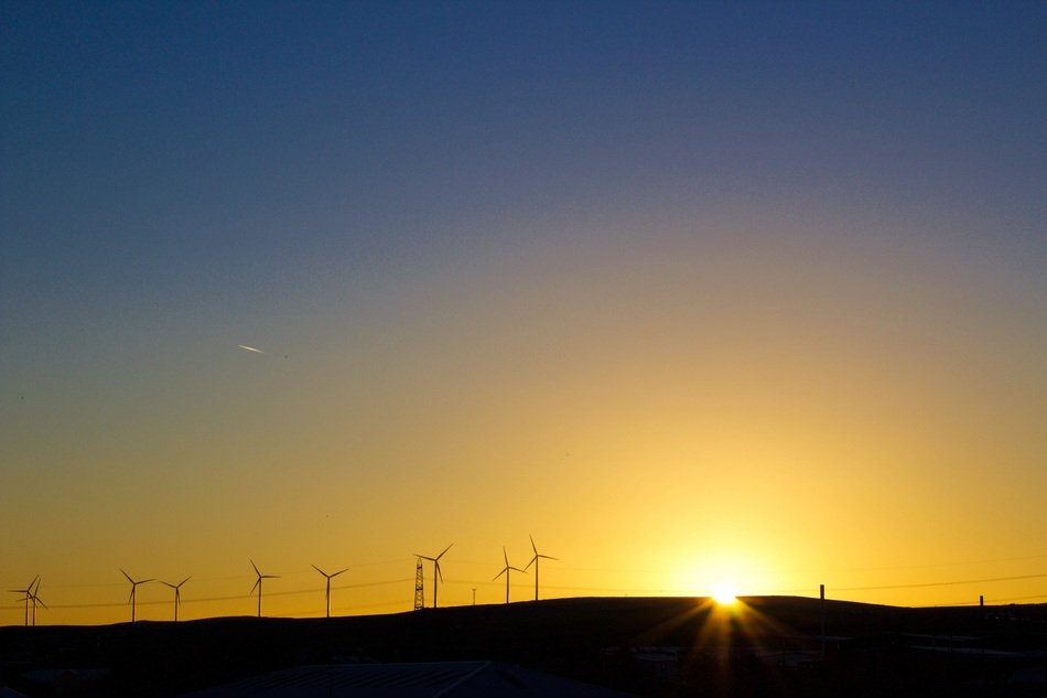sunset on the horizon against the background of windmills