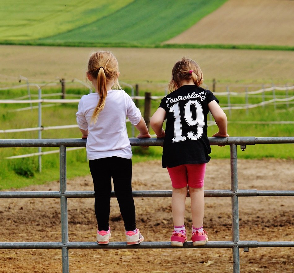 Girls are climbing on the fence