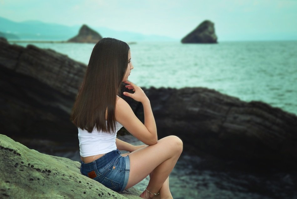 long-haired girl in shorts on the beach