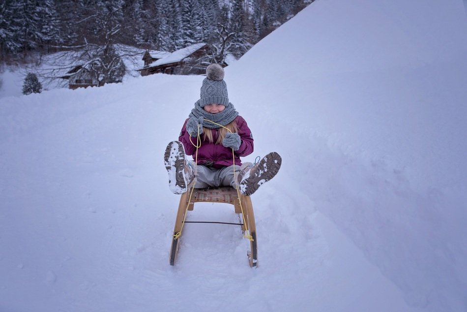 child rushes on a sleigh in the snowy nature