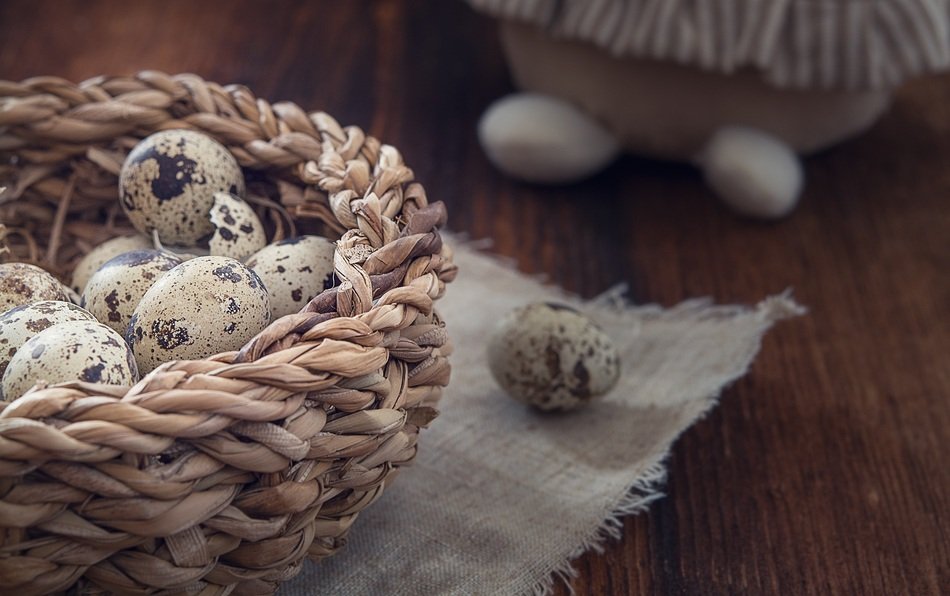 quail eggs in a wicker basket on the table