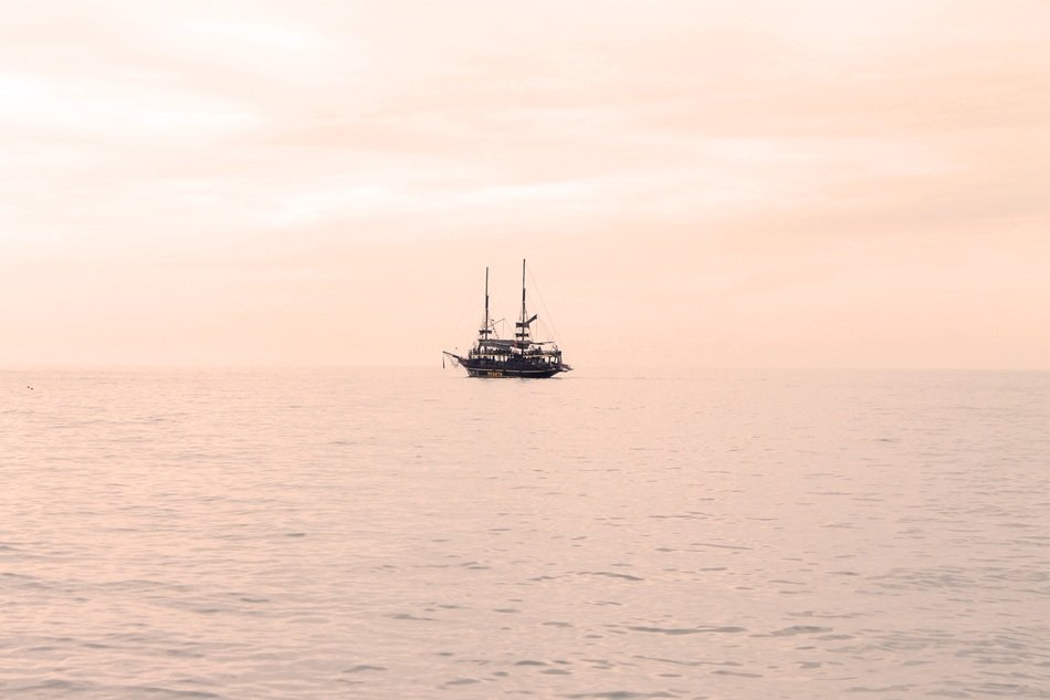 yacht in the sea against the pink sky