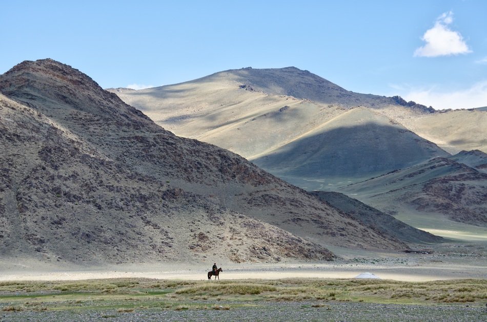 distant view of a rider in the mountains of mongolia