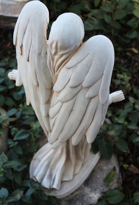 white sculpture of an angel in the garden