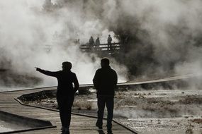 black and white photo of people near a geyser