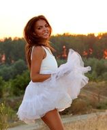 Smiling girl in white dress in the evening