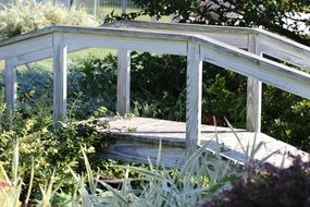 white wooden bridge over a creek in a park