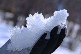 man holds snow in his hand