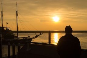 Human on a sail ship at the sunset