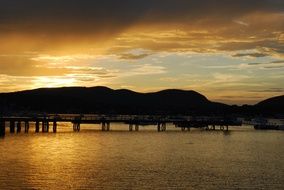 Beautiful long pier and mountains on Seacoast at colorful scenic sunset