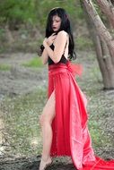 brunette woman in red skirt in the forest