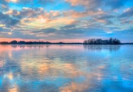 Colorful winter Sunset sky mirroring on calm Lake