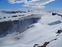 waterfall on a rock with snow in iceland