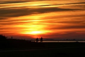 two bikers at sunset near wadden sea